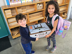 school kids holding produce box