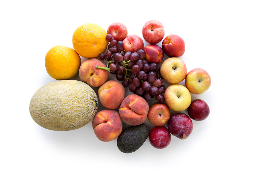 a mix of fruit including oranges, canteloup, peaches, grapes